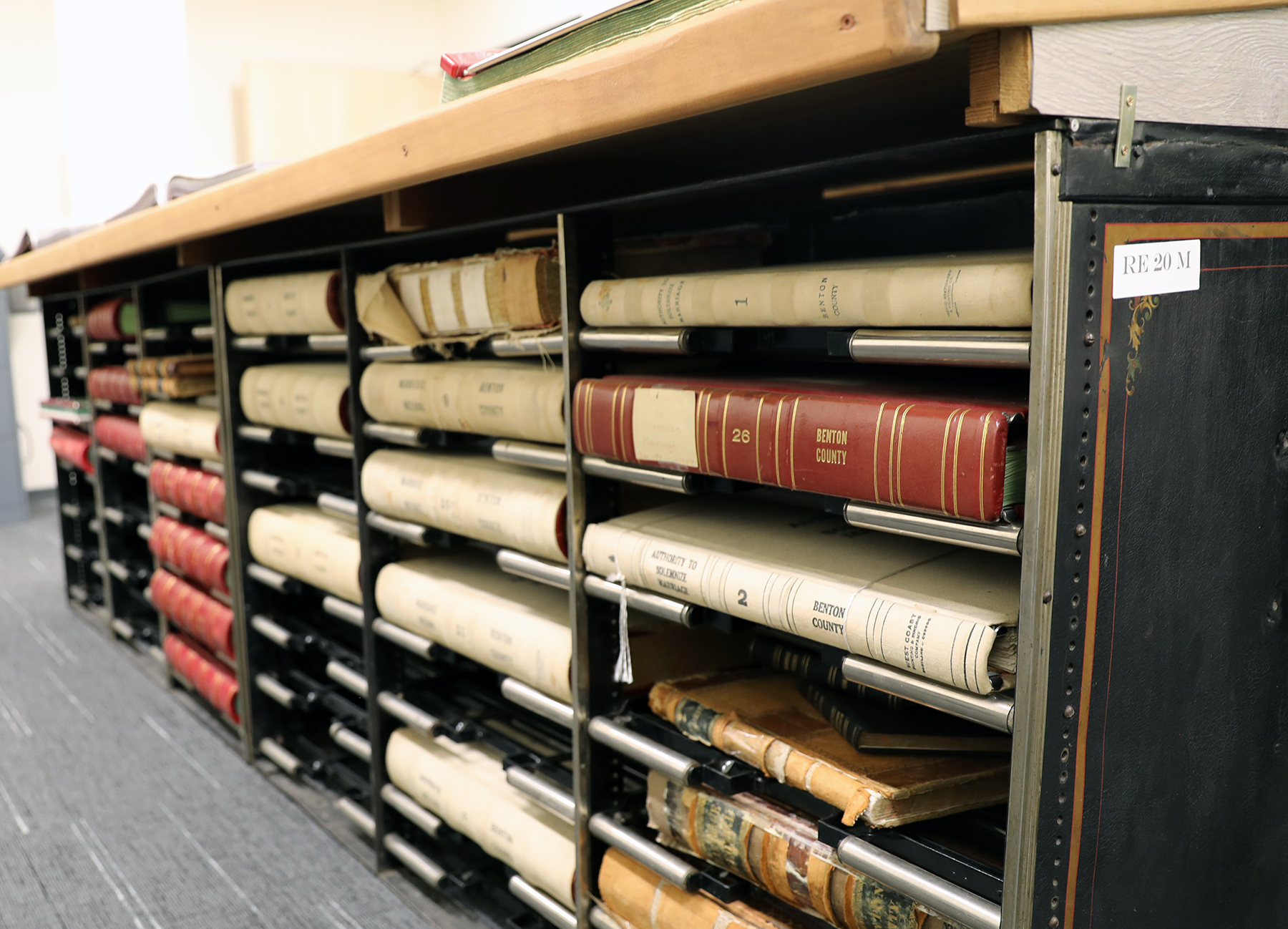 A close up of large worn books with various numbers and "Benton County" written on the spine, showing the County's physical archives