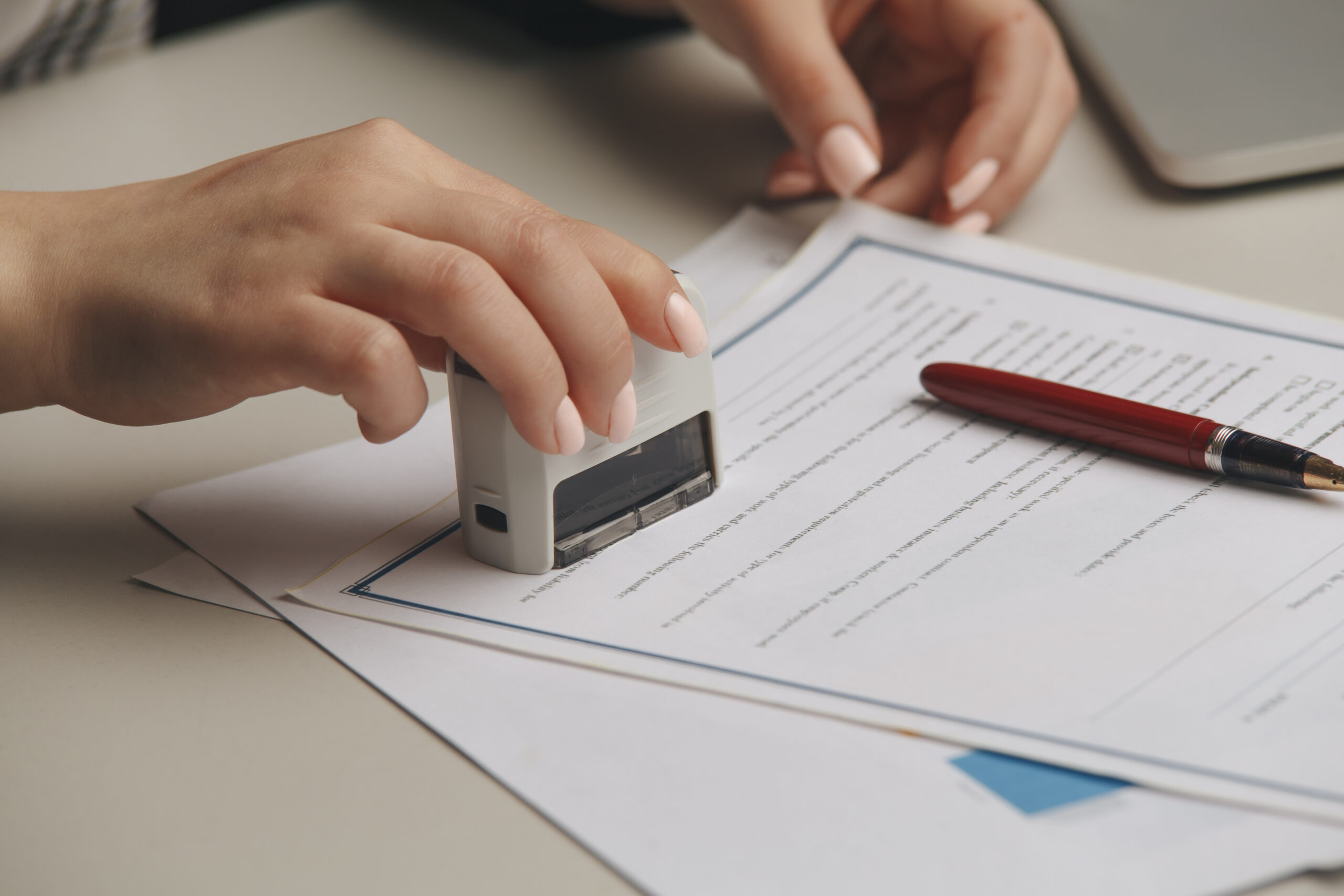 A person stamps a paper with a notary stamp